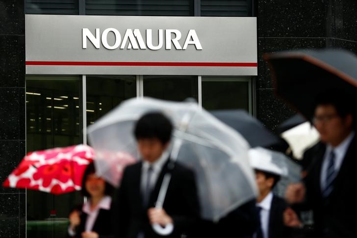 © Reuters. People walk past a branch of the Nomura financial services group in Tokyo