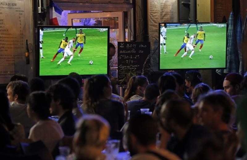 © Reuters. Clientes miran un partido de la Copa del Mundo 2014 en una cafetería en Marsella, Francia
