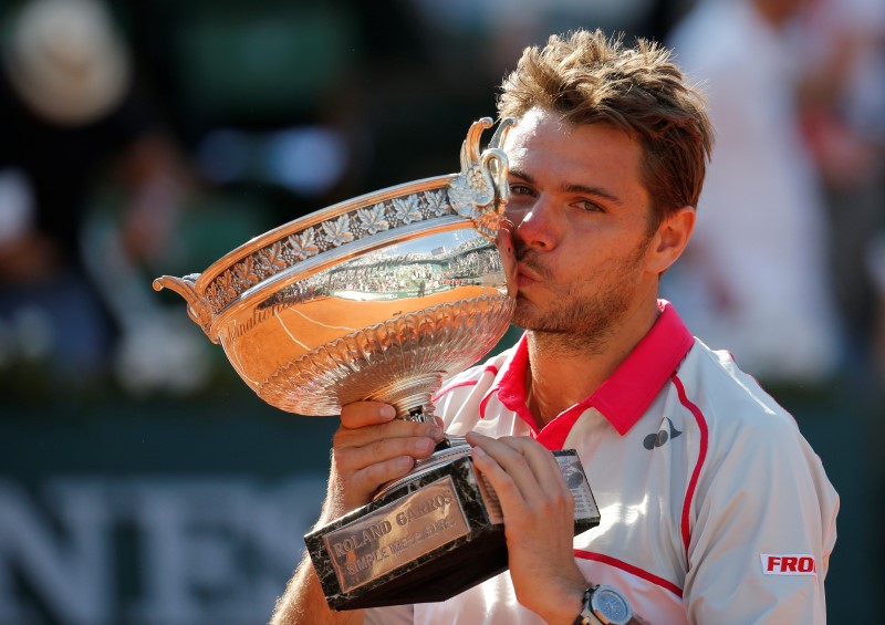 © Reuters. Stan Wawrinka of Switzerland kisses the trophy as he poses during the ceremony after winning the men's singles final match against Novak Djokovic of Serbia at the French Open tennis tournament at the Roland Garros stadium in Paris