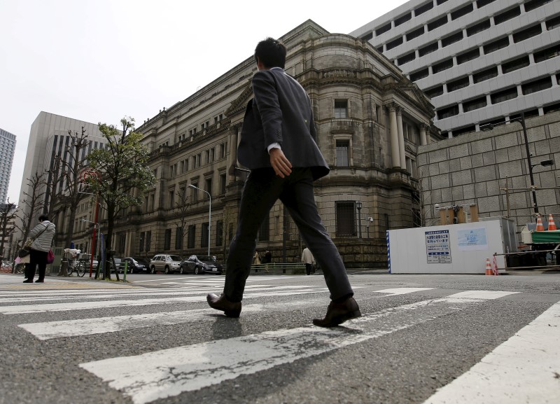 © Reuters. Businessman walks past the Bank of Japan (BOJ) building in Tokyo