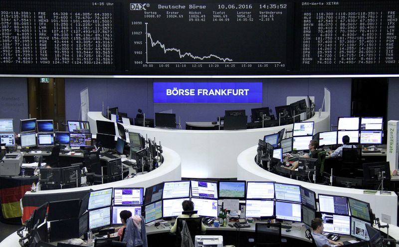 © Reuters. Traders work at their desks in front of the German share price index, DAX board, at the stock exchange in Frankfurt