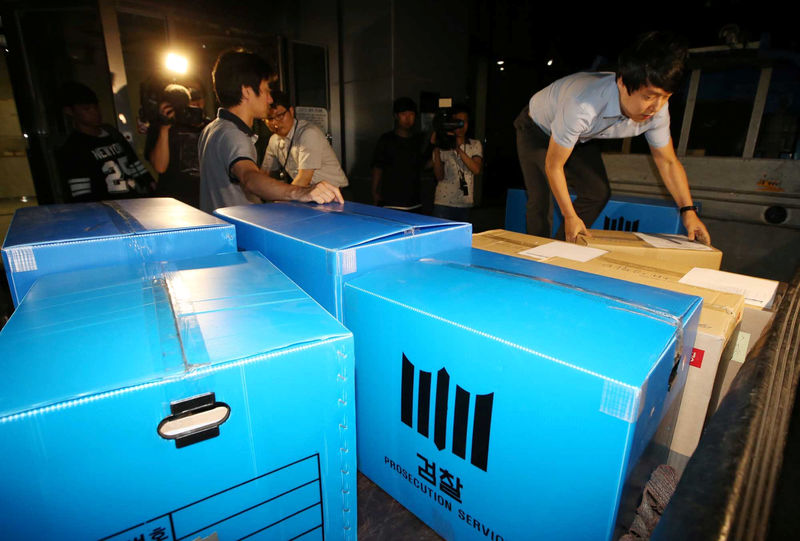 © Reuters. Investigators from the prosecution office carry boxes containing confiscated articles at Lotte Group's headquarters in Seoul