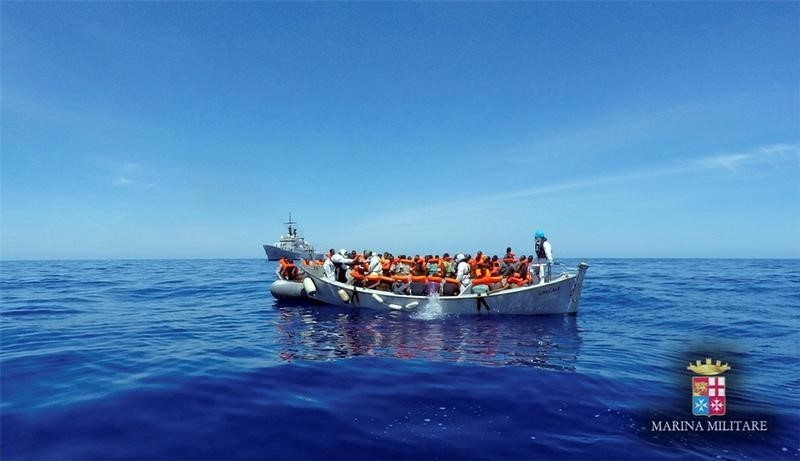 © Reuters. En la imagen de archivo, inmigrantes esperan en un bote durante una operación de rescate realizada por el barco Gracale de la Armada italiana costa afuera de Sicilia