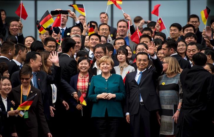 © Reuters. German Chancellor Merkel and Chinese Premier Li pose with students after their visit to the German University in Hefei