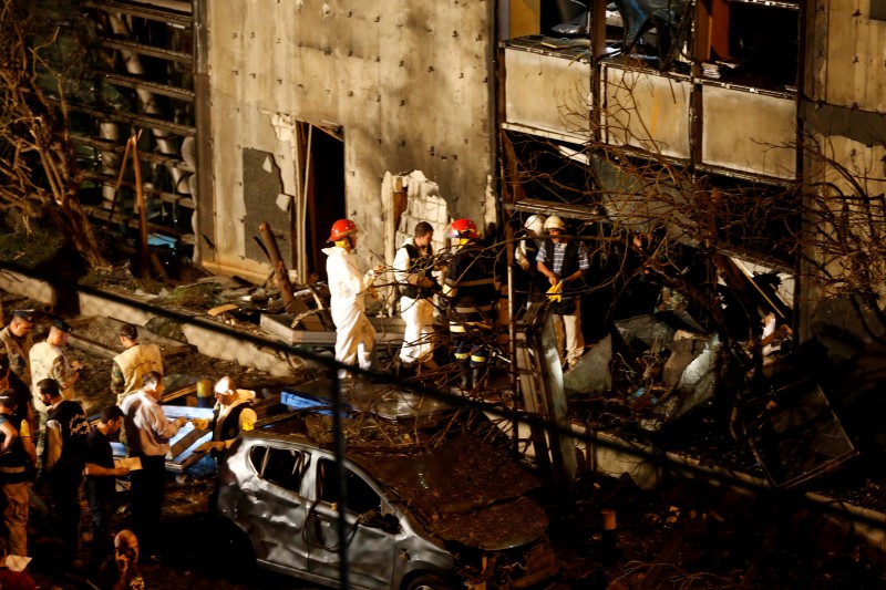 © Reuters. Forensic inspectors examine the site of an explosion at the headquarters of the Lebanese Blom Bank in Beirut
