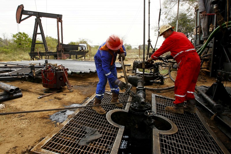 © Reuters. Men work at an oil pump in Lagunillas, Ciudad Ojeda