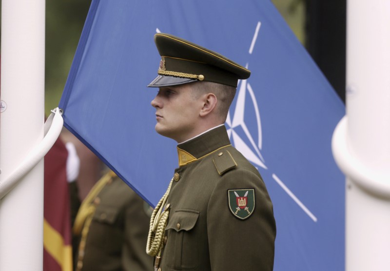 © Reuters. A Lithuanian army soldier stands near the NATO flag during the NATO Force Integration Unit inauguration event in Vilnius