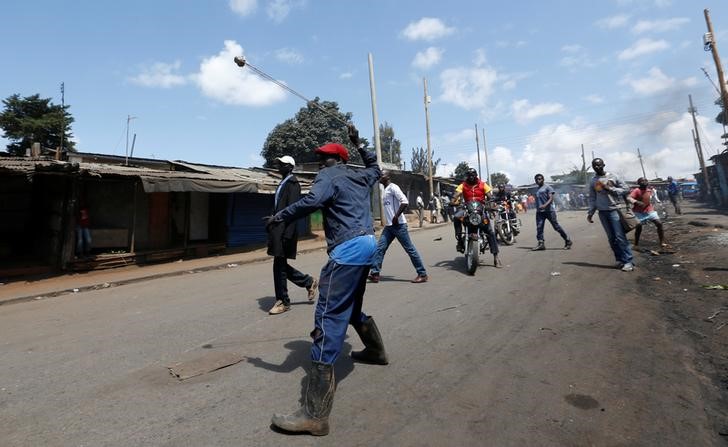 © Reuters. A supporter of Kenya's opposition CORD uses a sling to hurl stones towards their opponents during a protest against at the IEBC in Nairobi