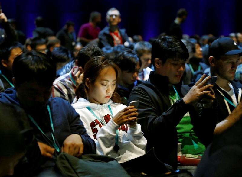 © Reuters. Attendees work on their devices before Apple Inc.'s 2016 Worldwide Developers Conference in San Francisco, California