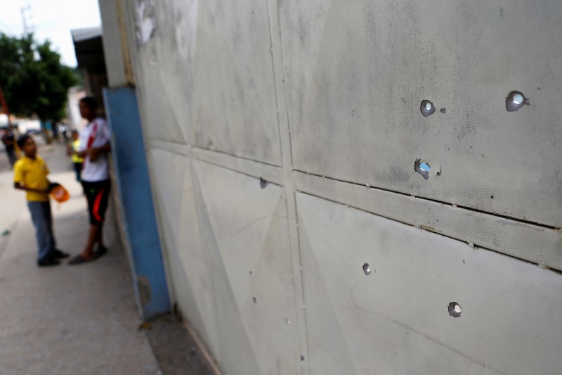 © Reuters. Bullet holes are seen after a gunfight outside a MERCAL, a state-run supermarket in a slum in Caracas