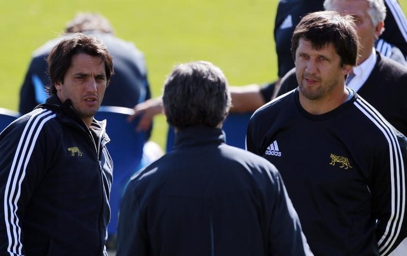 © Reuters. Argentina's rugby team former captain Pichot and head coach Phelan talk to the team's operations manager Salice during a training session in Dunedin