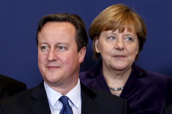 © Reuters. Britain's PM Cameron and Germany's Chancellor Merkel pose for a family photo during a EU leaders summit in Brussels