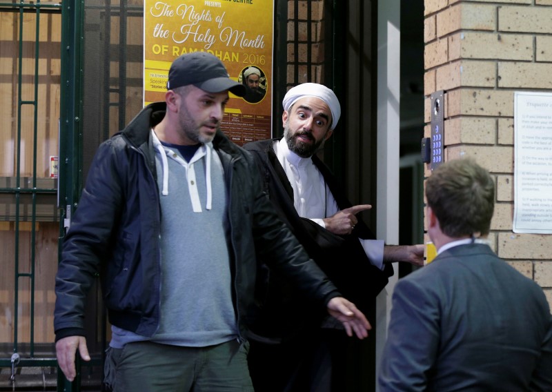 © Reuters. Farrokh Sekaleshfar, a British-born doctor and senior Shi'ite Muslim scholar, is prevented from speaking to a journalist as he arrives at the Imam Husain Islamic Centre in Sydney