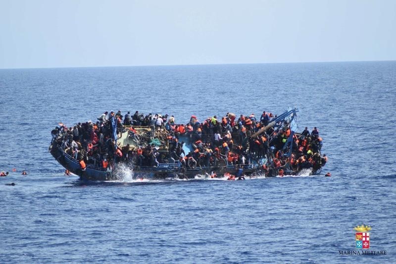 © Reuters. Migrants are seen on a capsizing boat before a rescue operation by Italian navy ships "Bettica" and "Bergamini" off the coast of Libya