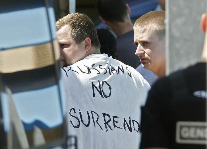 © Reuters. Russian soccer fans are ushered off a bus by gendarmes in Mandelieu near Cannes in southern France