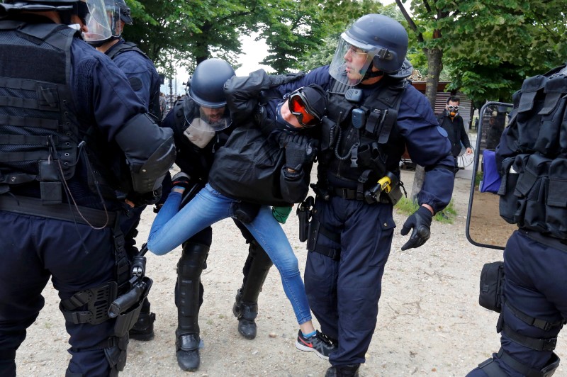 © Reuters. French CRS riot police apprehend a demonstrator during clashes at the Invalides square during a demonstration in Paris