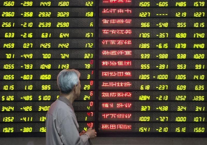 © Reuters. An investor looks at an electronic screen showing stock information at a brokerage house in Nanjing