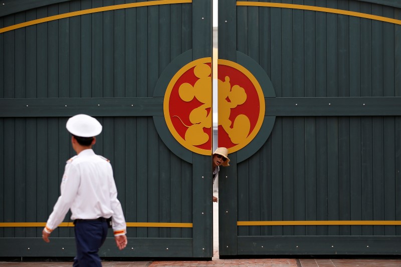 © Reuters. A woman stands outside a gate in Shanghai Disney Resort during a three-day Grand Opening events in Shanghai