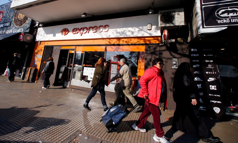 © Reuters. People walk past stores in Buenos Aires