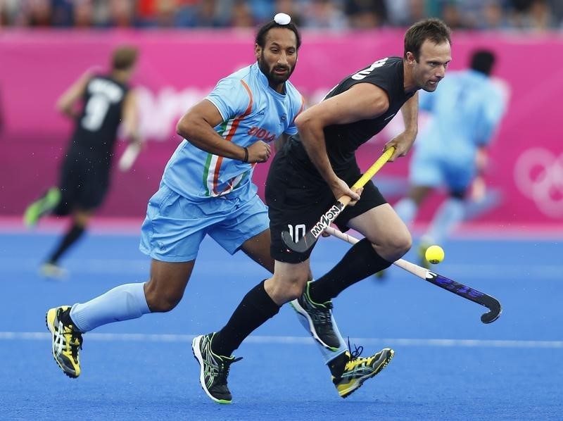 © Reuters. India's Singh challenges New Zealand's Archibald during their men's Group B hockey match at the London 2012 Olympic Games at the Riverbank Arena on the Olympic Park