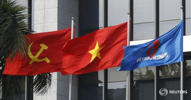 © Reuters. Флаг PetroVietnam (справа), флаг Вьетнама (в центре) и флаг Коммунистической партии Вьетнама в Ханое