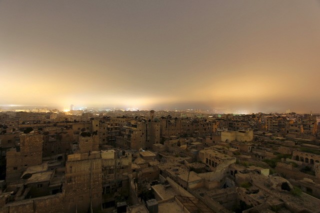 © Reuters. A general view shows damaged buildings in Aleppo city at night