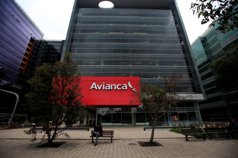 © Reuters. A man sits in front of the Avianca airlines headquaters building in Bogota