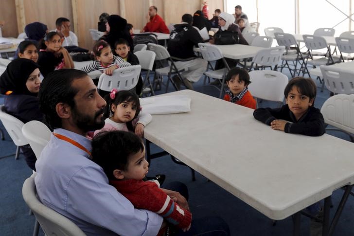 © Reuters. Syrian refugee families wait to register their information at the U.S. processing centre in Amman