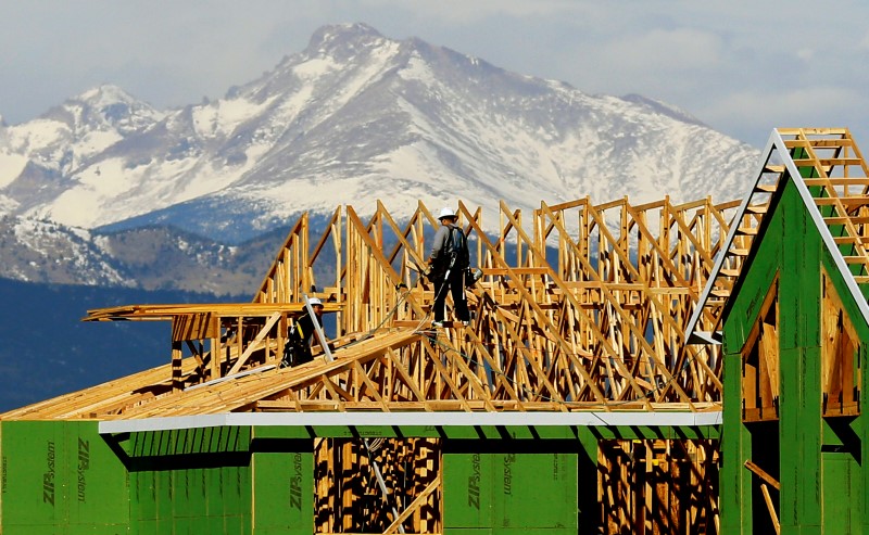 © Reuters. Workers install a roof on a multi-family building against the backdrop of the Rocky Mountains in Broomfield