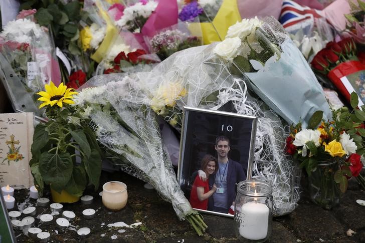 © Reuters. A photograph of Labour Member of Parliament Jo Cox with her husband Brendan outside Number 10 Downing Street, stands with floral tributes near the scene where Cox was killed in Birstall