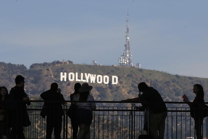 © Reuters. People look on and photograph the famed Hollywood sign as preparations continue for the 88th Academy Awards in Hollywood, Los Angeles