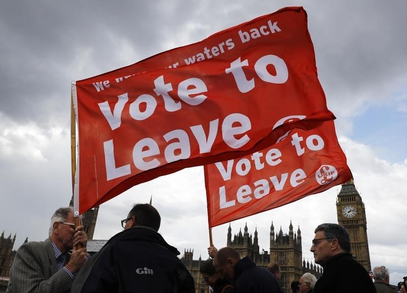 © Reuters. Leave the European Union campaigners wave banners near Parliament in London