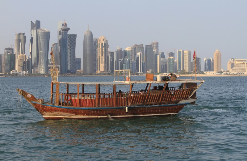 © Reuters. People travel in a traditional boat at Doha Corniche, Qatar