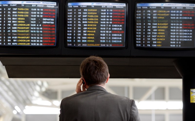 © Reuters. Passenger makes phone call in front of information board indicating cancelled flights at Sofia airport