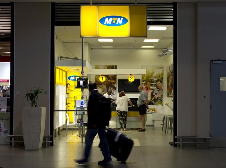 © Reuters. Travellers walk past an MTN telecom shop at King Shaka International Airport in Durban, South Africa