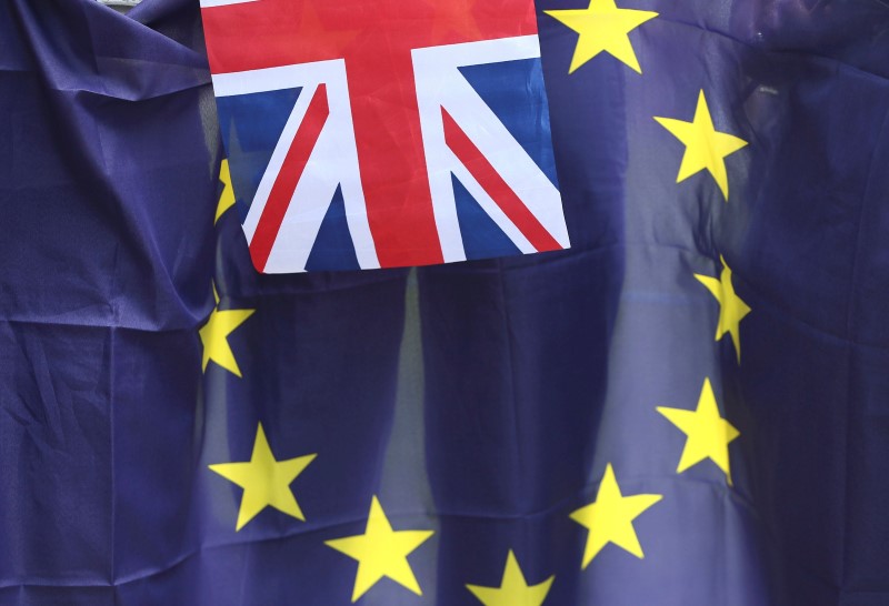 © Reuters. A British Union flag flies in front of an EU flag during a pro-EU referendum event at Parliament Square in London