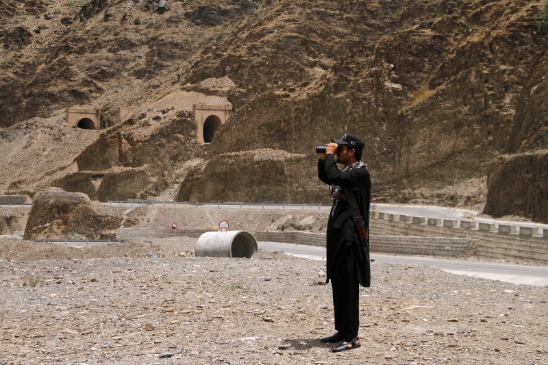 © Reuters. A member of Pakistan's Frontier Corps uses binoculars to survery the border region outside Torkham