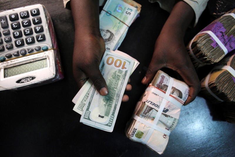 © Reuters. A trader changes dollars with naira at a currency exchange store in Lagos