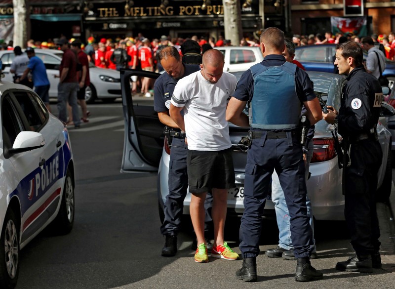 © Reuters. A fan is detained by police in Toulouse - EURO 2016