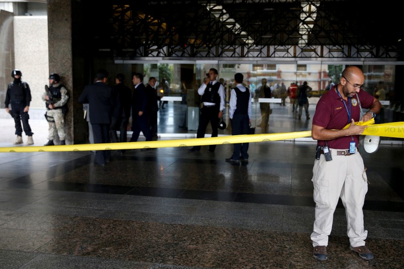 © Reuters. A worker puts up a security tape at the main entrance of the Venezuela's Central Bank building in Caracas