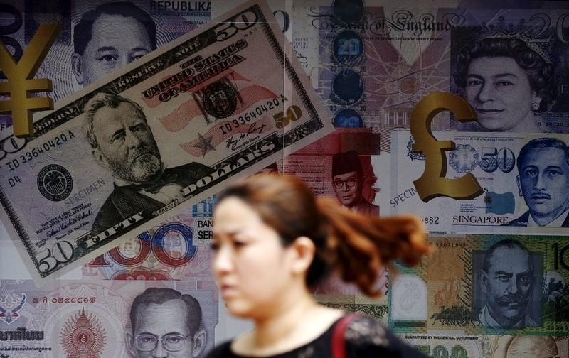 © Reuters. A woman walks past money exchange shop in Kuala Lumpur, Malaysia