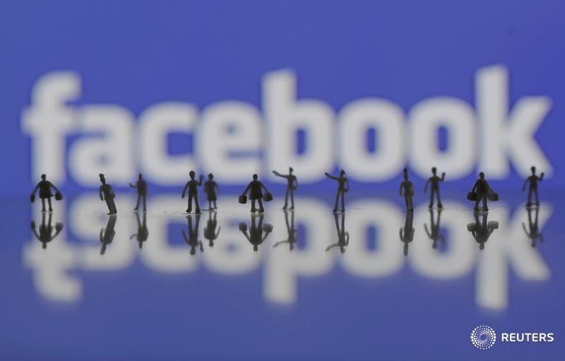 © Reuters. Photo illustration of 3D-printed models of people in front of a Facebook logo