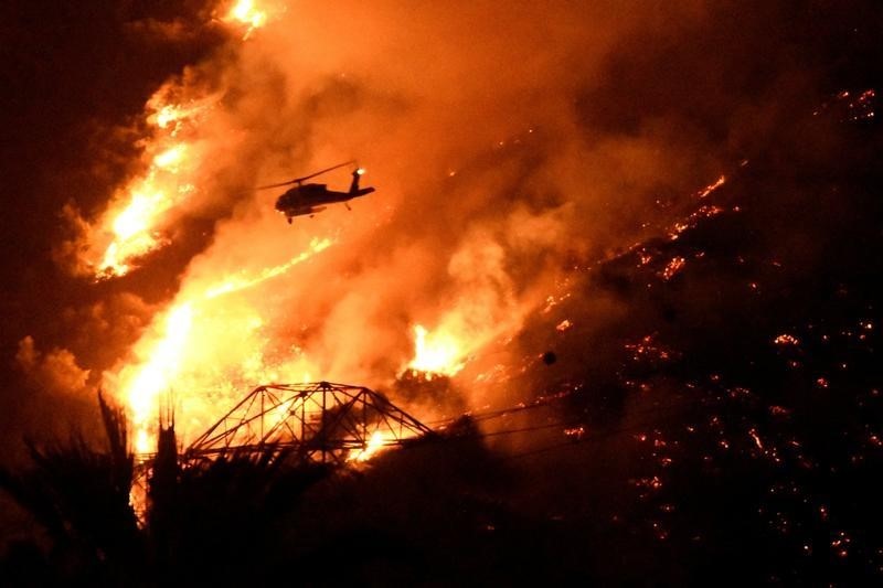 © Reuters. عمال الإطفاء يكافحون لاحتواء حرائق الغابات في كاليفورنيا