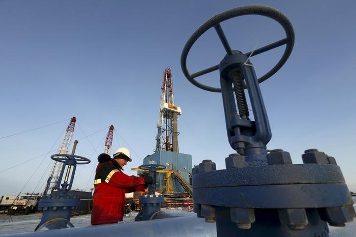© Reuters. Рабочий проверяет клапан трубопровода на Имилорском нефтяном месторождении