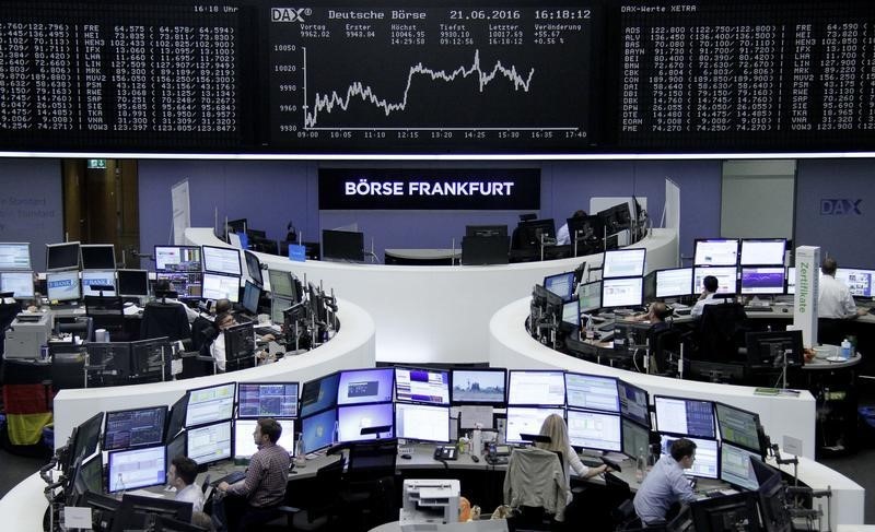 © Reuters. Traders work at their desks in front of the German share price index, DAX board, at the stock exchange in Frankfurt