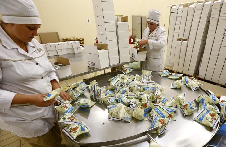 © Reuters. Рабочие в цеху Туровского молочного комбината