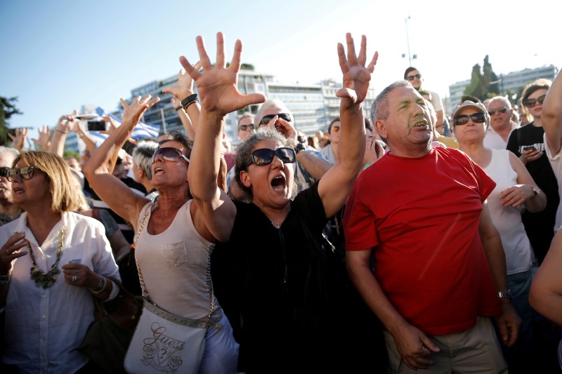 © Reuters. Anti-government demonstrators shout slogans during a protest outside the parliament in Athens