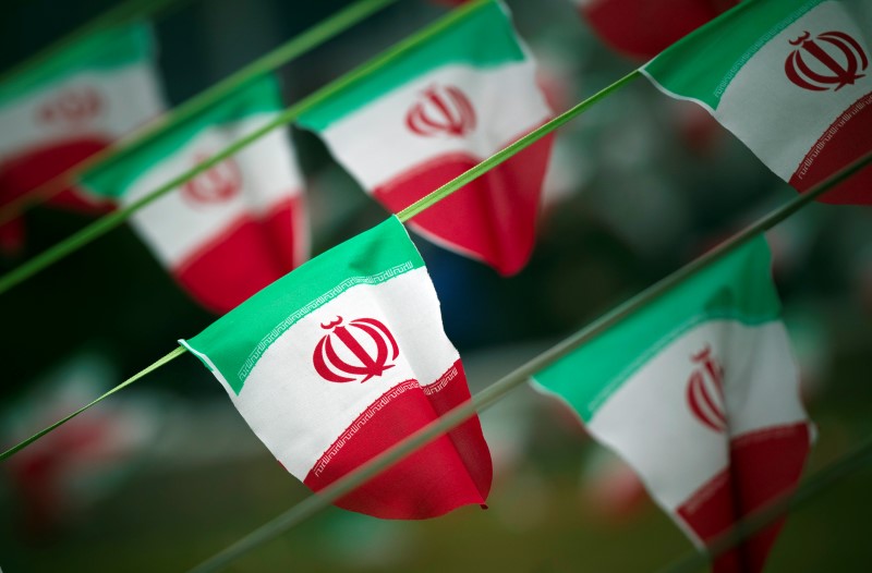 © Reuters. Iran's national flags are seen on a square in Tehran