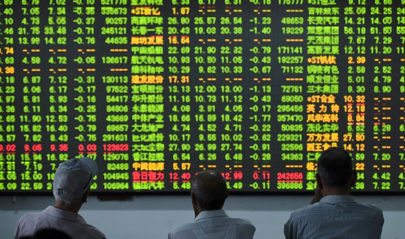 © Reuters. Investors look at an electronic screen showing stock information at a brokerage house in Hangzhou