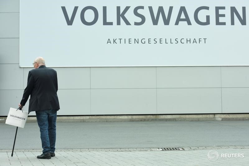 © Reuters. A Volkswagen shareholder using a walking stick carries a bag at the annual shareholder meeting in Hanover